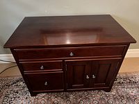 Cherry wood office desk front view showing two drawers on the left and a cupboard with double doors on the right.