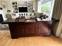 Front view of closed buffet/bar showing cherry finish and three cabinet doors