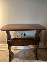 Front view of the antique style wooden side table showing its carved legs and overall shape.