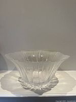 Side angle view showing the flared, scalloped rim and clear frosted ridged texture of the glass bowl.