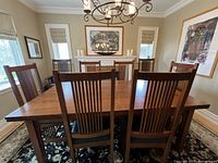 View of six side chairs and two armchairs around a wooden dining table showing finish and style