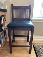 Single dark wood Arts and Craft style bar stool with slat back, showing the full front view including seat and legs.