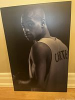 Full view of black and white image of Vince Carter on wood composite Plak-it board showing player from back and side with jersey name visible.