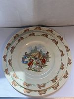 Top view of two plates showing bunny borders and central scenes with Bunnykins rabbit illustrations around a tent and pastoral setting.