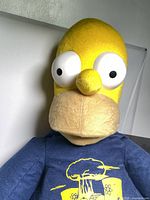 Front close-up photo of Homer Simpson plush figure in navy blue nuclear power plant hoodie