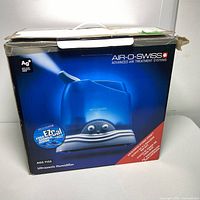 Original retail box showing blue and white Air-O Swiss ultrasonic humidifier with Ag+ antimicrobial and EZCal cleaning system branding.