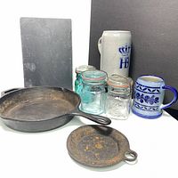 Full view of lot including cast iron pans, slate board, Mason jars, and steins.
