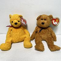 Two TY Beanie Baby bears side by side, showing front view, highlighting their colors and attached hang tags.