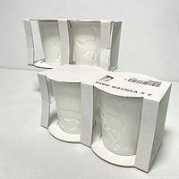 Six white candles in original IKEA packaging with visible embossed animal designs on candle surfaces.