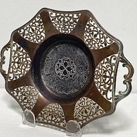 Front view of the antique silver plated dish showing octagonal shape, cutout patterns and engraved center.