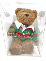 Front view of Ralph Lauren Bear that Cares in original display box showing green and red striped rugby shirt with white collar and embroidered Polo logo.