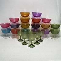 Front view of full set showing colorful dessert cups stacked and green champagne glasses in front