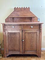 Front view showing two drawers, double doors, open shelf and sawtooth backsplash