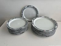 Two stacks of plates showing salad plates (smaller) and lunch plates (larger) with blue, red and green floral border design on white background