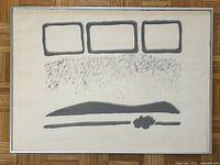 Framed lithograph on floor, showing full composition in grey tones with shapes and textured area.