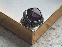 Front angled view of the sterling silver ring showing the amethyst-colored cushion-cut stone and braided band detail.