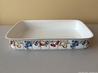 Front view of the rectangular white porcelain lasagna dish showing the detailed fruit motif along the front edge.