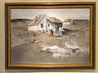 Full view of the framed oil on board painting showing the outdoor laundry scene with two buildings and laundry on the ground.