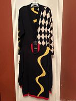 Both sweaters displayed hanging on door, full front view