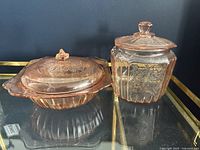 Photo showing both the covered vegetable dish and the cookie jar side by side on a glass shelf, highlighting the shape and lids.