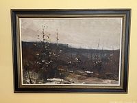 Framed vintage landscape oil painting hanging on a wall, showing the full artwork and frame with minor corner scuffs.