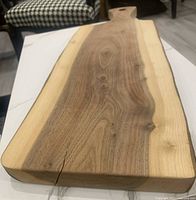Top view of the charcuterie board showing natural wood grain, smooth finish, and live edges.