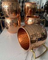 Set of 8 hammered copper Moscow Mule mugs, showing the texture and welded handles