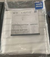 Photo showing the Wholistic queen size flat sheet packaged, highlighting the 400 thread count and Supima cotton labels.