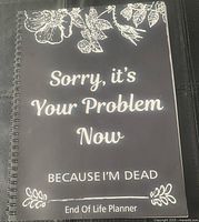 Front cover of the End of Life Planner book, black with white floral design, text 'Sorry, it's Your Problem Now Because I'm Dead'