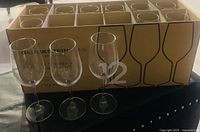 Box of 12 Gluckstein Home white wine glasses with three glasses displayed in front of the box.