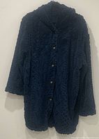 Front view of women's navy blue faux fur jacket with buttons and hood.