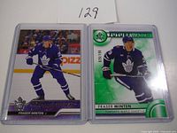 Two Fraser Minten hockey cards displayed side by side in protective sleeves, including one Future Watch RC numbered 029/199 and one Young Guns RC.