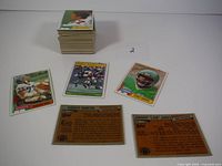 Stack of approximately 125 football trading cards showing front and backs of cards with players like Harvey Martin, Johnny Lam Jones, and Ken Greene.