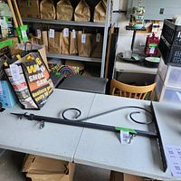 Full view of the metal retail sign bracket showing its size and decorative curved design elements.