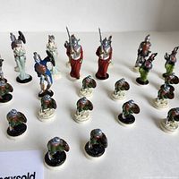 Photo showing group of hand-painted vintage miniatures in rows on white background.