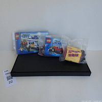 Photo showing two LEGO City sets' instruction manuals, some unassembled LEGO pieces in plastic bags, and one sealed 'Love You' themed LEGO kit in plastic packaging