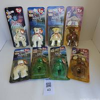 Front view of all 8 TY Beanie Babies in original sealed packaging, arranged in two rows showing each character name and packaging design.