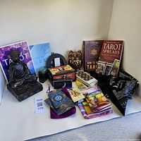 Overview of all items: Buddha tea light holder, Tarot and Oracle card decks with pouches, owl figurine, altar cloth, and books on Tarot.