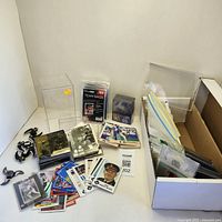 Overall view of mixed sports cards, card storage bags, and protective sleeves in a box and on surface