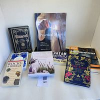 Seven books displayed in a row: Witchcraft, Practical Magic, Dream Dictionary, Numerology, Rocks & Minerals Field Guide, Crystal Rx, The Witch's Book of Self-Care.