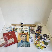 Photo of entire sports collectibles lot showing cards, bobblehead, mini bat, and card book album.