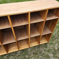Wood cubby unit showing internal shelves with visible water damage stains and pull-out functionality