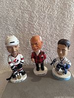 Photo showing all three figurines: Fleury, Cherry, and Curtis Joseph, arranged together with clear front views.