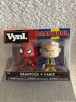 Front view of new in box Funko Vynl Deadpool and Cable figure set, showing both figures clearly through window packaging with branding and character names.