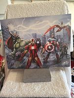 Poster showing Marvel superheroes in action with cityscape and lightning, featuring Iron Man, Hulk, Thor, Captain America, Black Widow, Falcon, and Hawkeye.