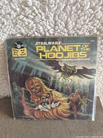 Front cover of the Star Wars Planet of the Hoojibs book and record,"The Further Adventures" series, edition 454. Shows Chewbacca and other characters.