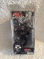 Front view of Kevin action figure in original plastic blister packaging with visible accessories and minor packaging wear.