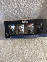Front view of the collectible box containing four Beatles glasses with different year designs and the Beatles band photo on the box
