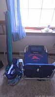 Tommy Bahama beach chair packed with umbrella and bag visible in background