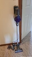 Full view of the Dyson cordless stick vacuum with wand and motorized floor head standing upright.